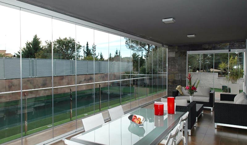 Cortinas de cristal replegadas a un lado de la terraza