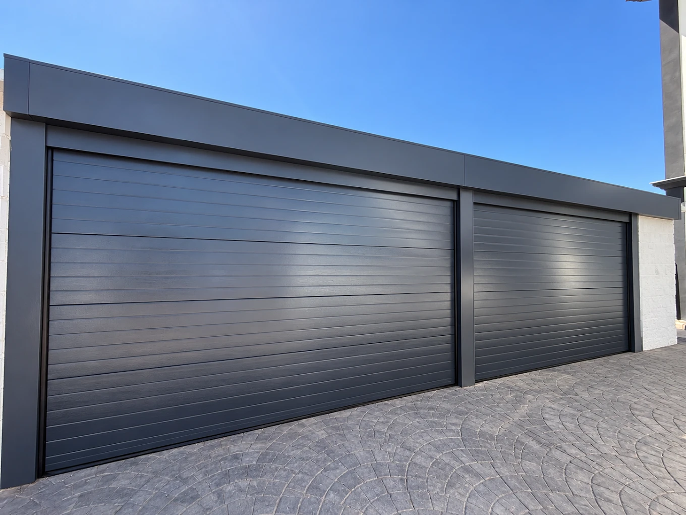 Dos puertas de garaje seccionales en gris antracita instaladas en una vivienda de Málaga